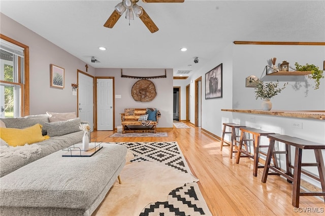 living room with light wood-type flooring, a ceiling fan, recessed lighting, and baseboards