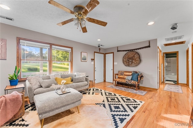 living room featuring baseboards, light wood-style floors, ceiling fan, and recessed lighting