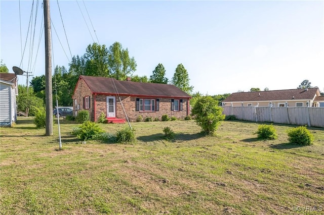 view of front of home featuring fence, a front lawn, and brick siding