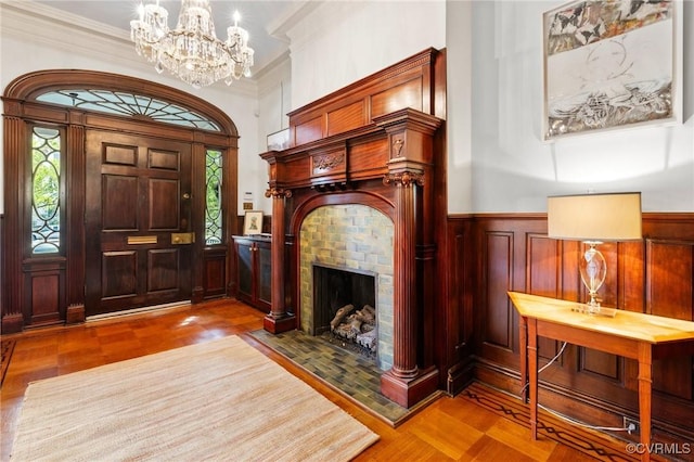 2218 Monument Ave, Richmond, VA 23220 - foyer with a chandelier, plenty of natural light, a wainscoted wall, ornamental molding, and a tiled fireplace