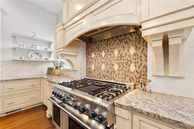2218 Monument Ave, Richmond, VA 23220 - kitchen with cream cabinetry, double oven range, backsplash, light stone countertops, and light wood-style flooring