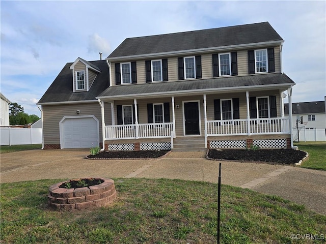 colonial-style house featuring a garage, a fire pit, fence, a porch, and driveway