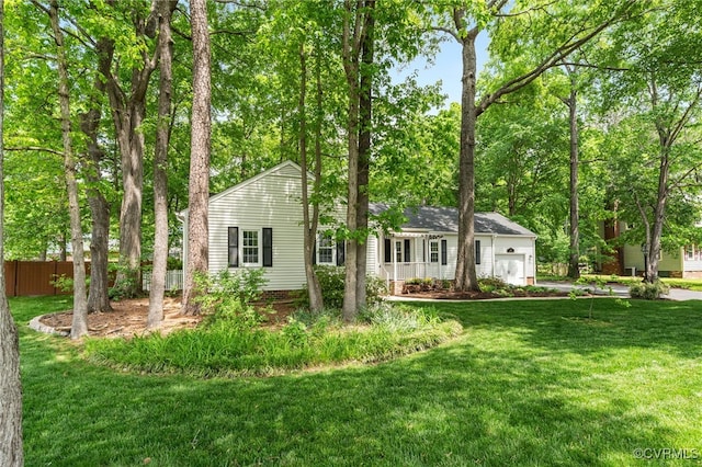 view of front of home with an attached garage, fence, and a front lawn