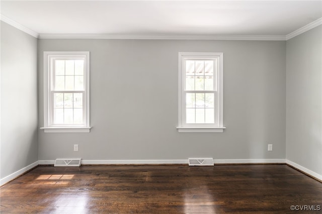 spare room featuring a healthy amount of sunlight, ornamental molding, and visible vents