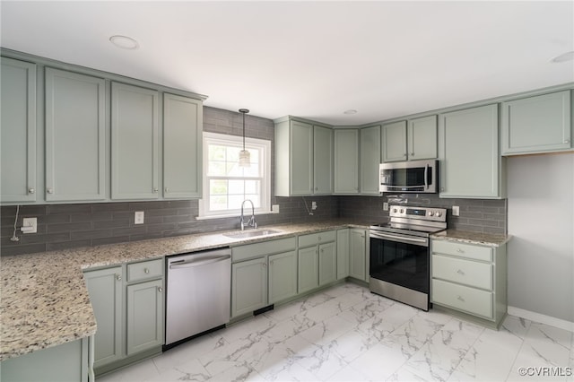 kitchen with a sink, appliances with stainless steel finishes, baseboards, and marble finish floor