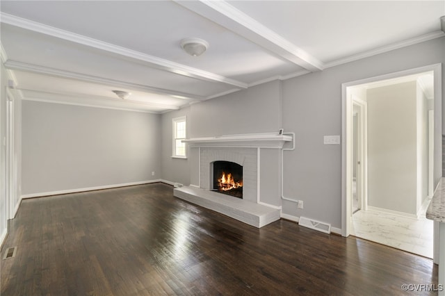 unfurnished living room with a brick fireplace, wood finished floors, and visible vents