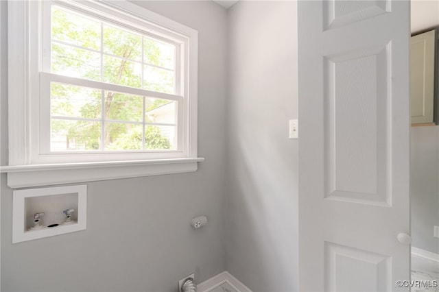 clothes washing area featuring washer hookup, baseboards, laundry area, and a wealth of natural light