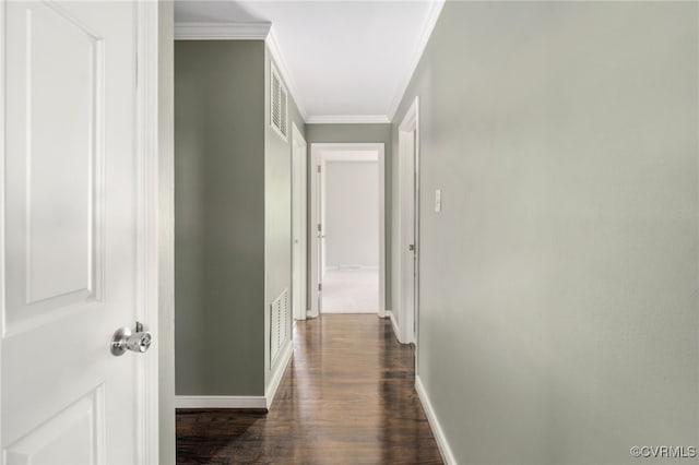 hallway with crown molding, baseboards, dark wood finished floors, and visible vents