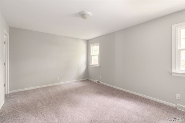 unfurnished room featuring baseboards, carpet flooring, and visible vents