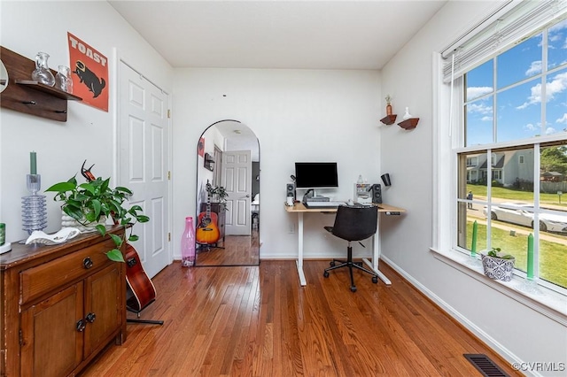 10701 Hamiltons Xing, Fredericksburg, VA 22408 - home office with arched walkways, baseboards, a wealth of natural light, and light wood finished floors
