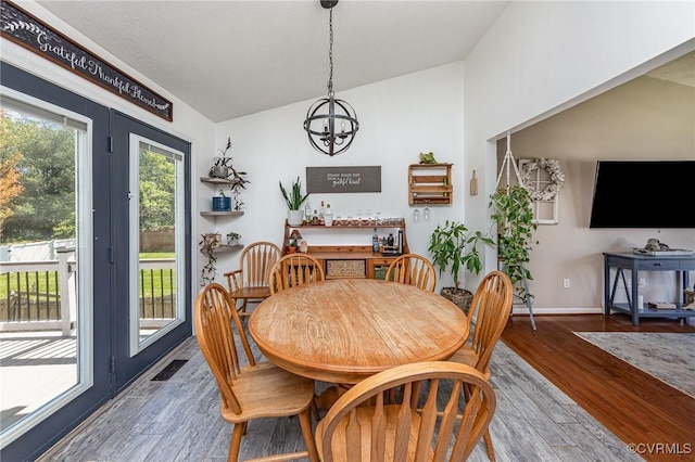 10701 Hamiltons Xing, Fredericksburg, VA 22408 - dining area featuring a notable chandelier, visible vents, baseboards, wood finished floors, and vaulted ceiling