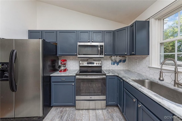 10701 Hamiltons Xing, Fredericksburg, VA 22408 - kitchen featuring tasteful backsplash, vaulted ceiling, a sink, stainless steel appliances, and light wood-style flooring