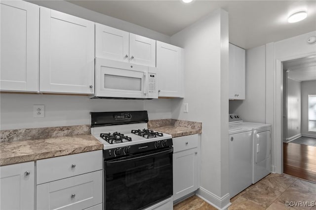 kitchen featuring baseboards, white microwave, washer and clothes dryer, white cabinets, and range with gas cooktop