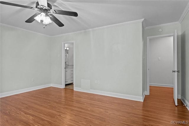 spare room featuring crown molding, ceiling fan, baseboards, and wood finished floors