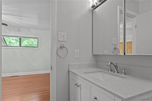 bathroom featuring vanity, baseboards, wood finished floors, and visible vents