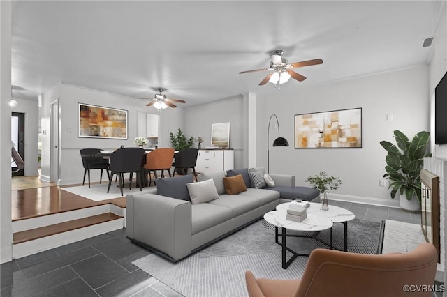 living area featuring baseboards, ceiling fan, and visible vents