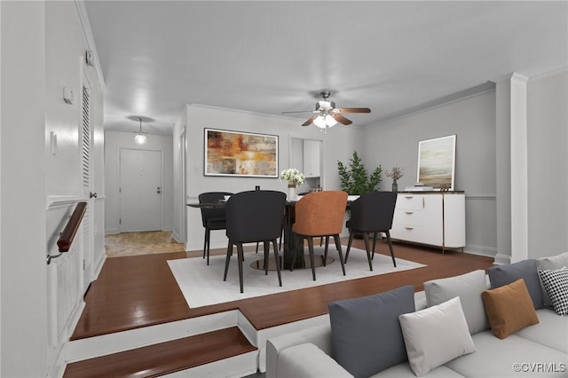 living area featuring baseboards, ceiling fan, and wood finished floors