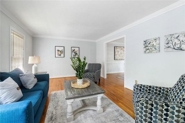 living area featuring crown molding, wood finished floors, and baseboards