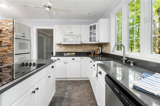 kitchen with white appliances, a sink, plenty of natural light, tasteful backsplash, and crown molding