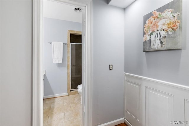 full bath featuring a stall shower, toilet, and tile patterned floors
