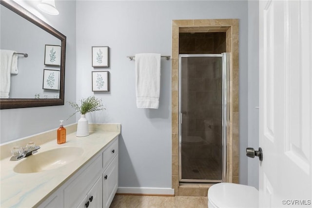 bathroom featuring a shower stall, toilet, vanity, baseboards, and tile patterned floors