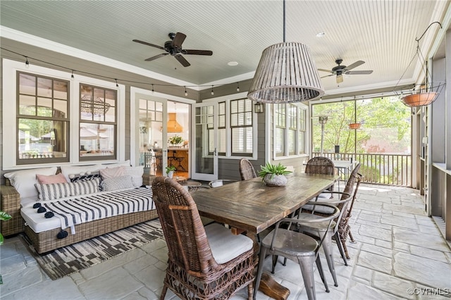 sunroom with ceiling fan, outdoor dining area, and healthy amount of natural light