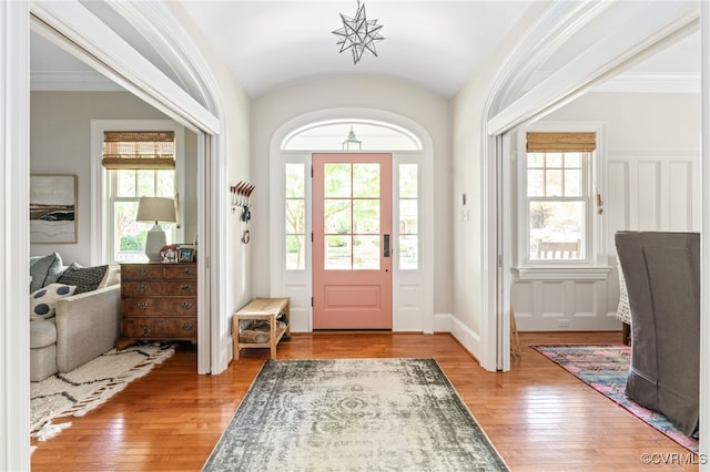 entryway with wood-type flooring and lofted ceiling