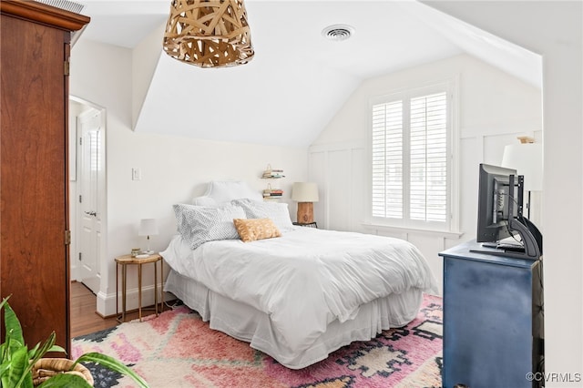 bedroom featuring wood finished floors and vaulted ceiling