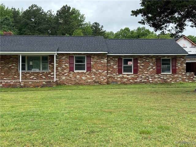 ranch-style house featuring brick siding, a shingled roof, and a front lawn