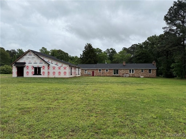 view of front facade with a chimney and a front lawn