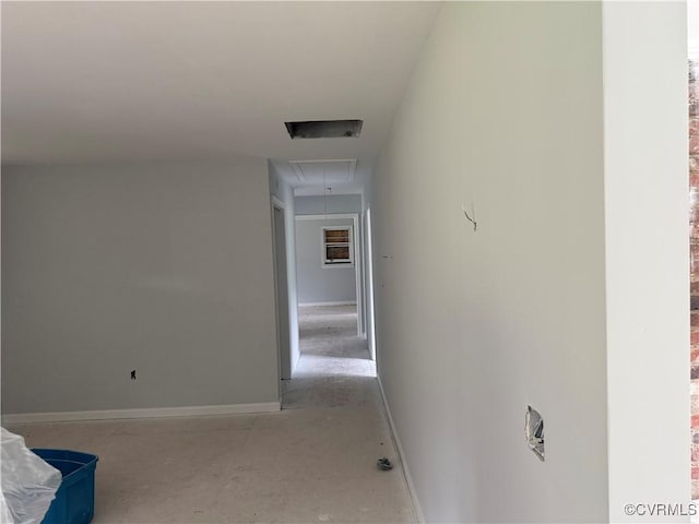 hallway featuring baseboards and attic access