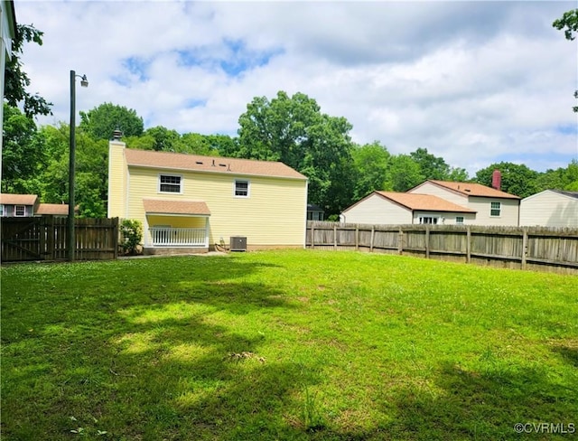 rear view of property featuring central air condition unit and a chimney