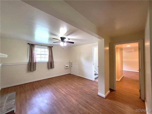 unfurnished living room featuring wood finished floors, a ceiling fan, and baseboards