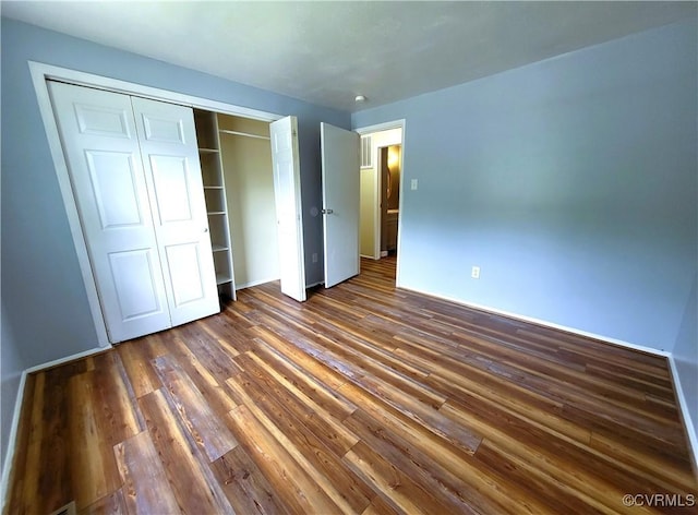 unfurnished bedroom featuring wood finished floors and a closet