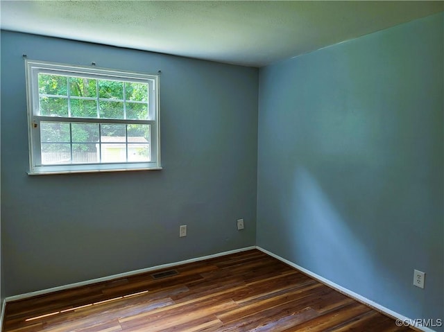 empty room featuring wood finished floors and baseboards