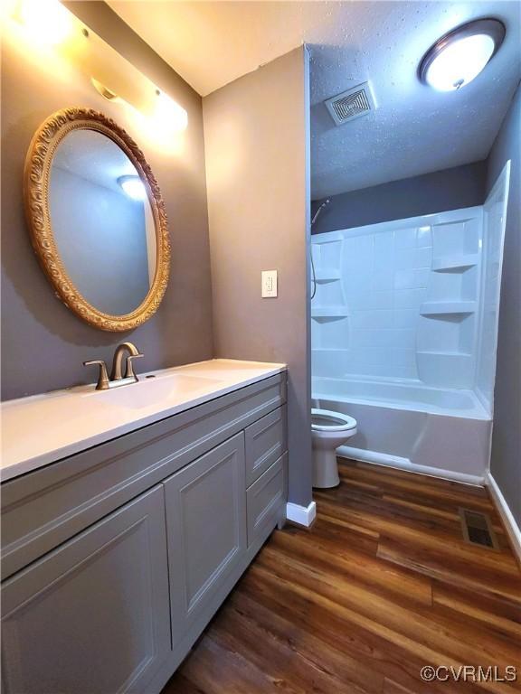 bathroom featuring wood finished floors, toilet, baseboards, and vanity