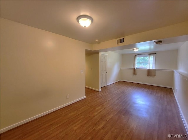 spare room featuring wood finished floors and baseboards