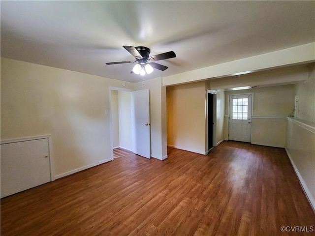 unfurnished bedroom featuring wood finished floors, baseboards, and a ceiling fan