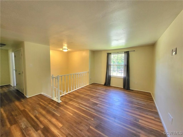 unfurnished room with wood finished floors and baseboards