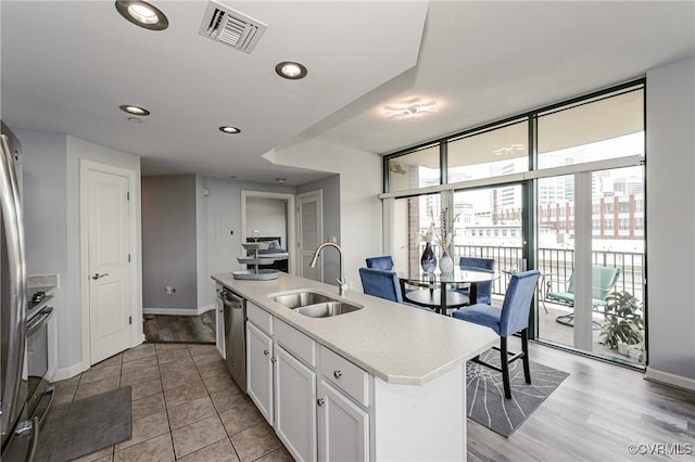 kitchen with white cabinets, visible vents, plenty of natural light, and a sink