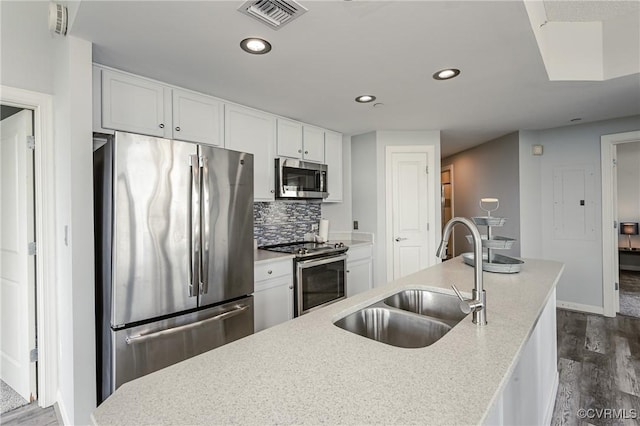 kitchen with a sink, stainless steel appliances, dark wood-style floors, and visible vents