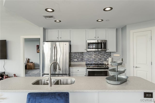 kitchen with a sink, white cabinets, stainless steel appliances, and visible vents