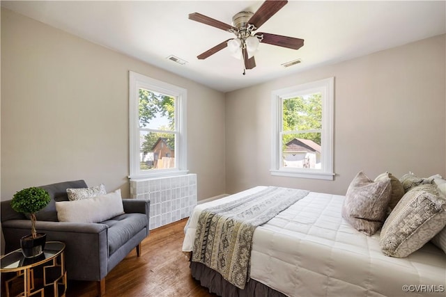 bedroom featuring multiple windows, wood finished floors, and ceiling fan