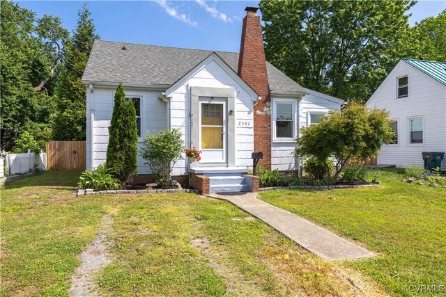 bungalow-style home with a chimney and roof with shingles