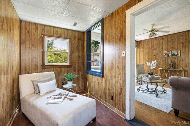 bedroom with wooden walls, baseboards, and wood finished floors