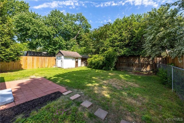 view of yard featuring an outbuilding, a patio, and a storage unit