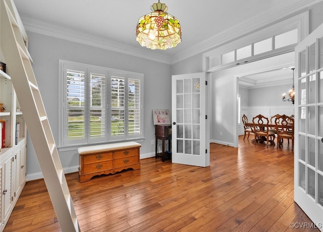 interior space featuring french doors, light wood-style flooring, crown molding, and a chandelier