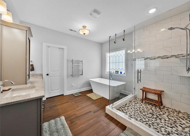 full bathroom featuring vanity, a freestanding tub, visible vents, and a stall shower