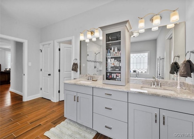 full bath featuring a sink, a stall shower, and a wealth of natural light