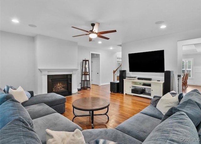 living area with a ceiling fan, recessed lighting, light wood finished floors, and a fireplace